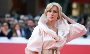 Nancy Brilli con un abito bianco voluminoso e una cintura con fibbia a B, posa sul red carpet.