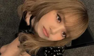 Primo piano di una giovane donna con capelli biondo cenere e carnagione media, che guarda verso l'alto con un'espressione dolce.
