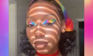 Make up pride: un volto con un trucco arcobaleno sugli occhi e una fascia colorata.