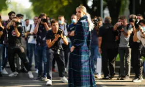 Modella con abito lungo a fantasia, circondata da fotografi. Un'anteprima della fashion week milano 2026.