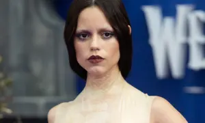 Donna con trucco Halloween semplice: occhi scuri, labbra bordeaux e pelle effetto squame.