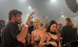 Matteo Berrettini con la sua fidanzata e amici in un locale notturno, tra DJ e folla festante.