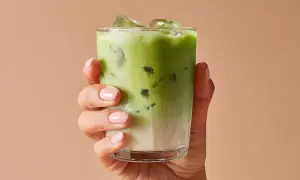 Mano con un bicchiere di matcha ghiacciato. Attenzione alle matcha controindicazioni per goderselo al meglio.