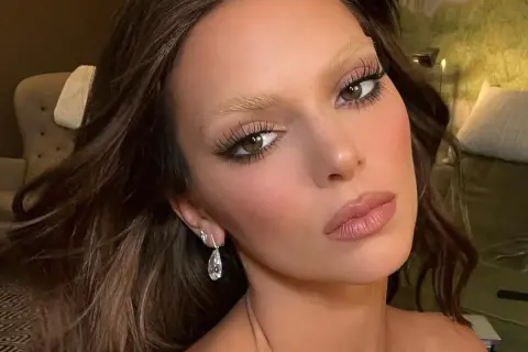 Sopracciglia bionde e folte, un look audace per chi vuole sapere come schiarire le sopracciglia. Occhi castani, labbra rosa e orecchini pendenti.