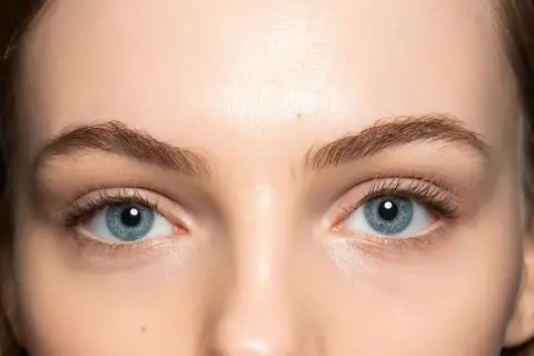 Occhi azzurri luminosi, evidenziati da un trucco leggero e naturale che ne esalta la profondità. Ciglia lunghe e definite completano il look.