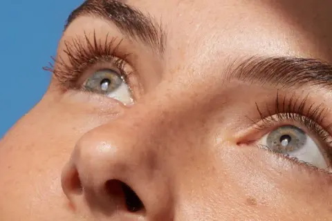 Occhi con ciglia lunghe e folte, pelle luminosa con lentiggini. Scopri come struccarsi senza struccante per un viso fresco e naturale.
