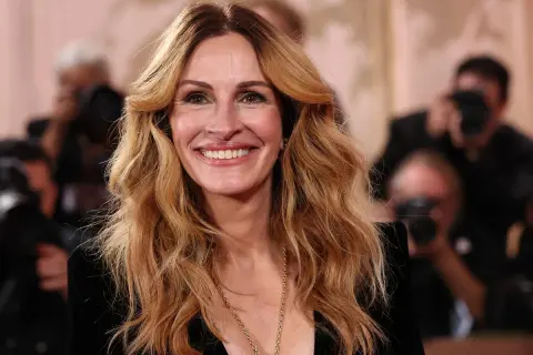 Julia Roberts oggi, sorridente e radiosa, con i suoi iconici capelli biondi mossi e una collana dorata.