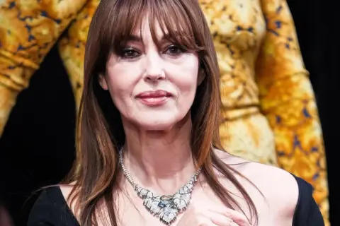 Bellucci oggi, con un magnifico collier di diamanti e un abito dorato.