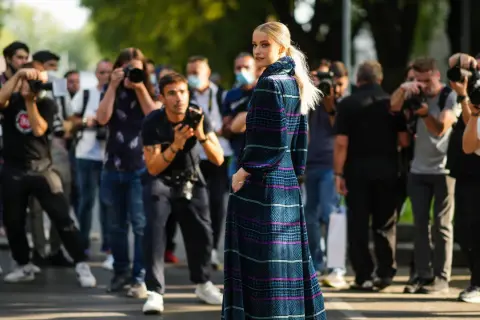 Modella con abito lungo a fantasia, circondata da fotografi. Un'anteprima della fashion week milano 2026.