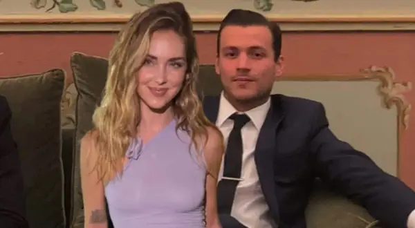 Chiara Ferragni e il suo fidanzato Fedez, sorridenti, seduti su un divano in un ambiente elegante.