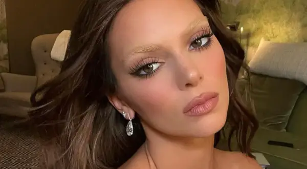 Sopracciglia bionde e folte, un look audace per chi vuole sapere come schiarire le sopracciglia. Occhi castani, labbra rosa e orecchini pendenti.