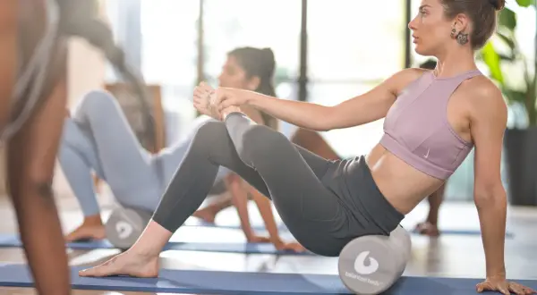 Donne in posa con rulli per pilates, un allenamento che tonifica e migliora la flessibilità.