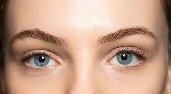 Occhi azzurri luminosi, evidenziati da un trucco leggero e naturale che ne esalta la profondità. Ciglia lunghe e definite completano il look.