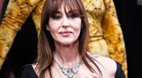 Bellucci oggi, con un magnifico collier di diamanti e un abito dorato.