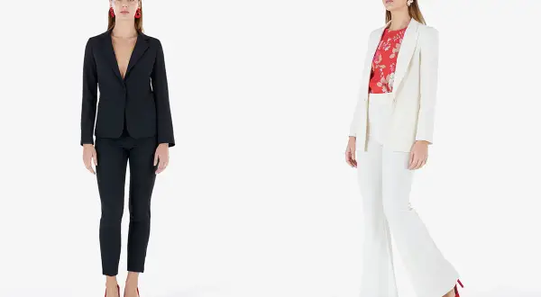 Modelli con giacca e pantaloni eleganti. Una con giacca nera e pantaloni slim, l'altra con giacca bianca e pantaloni a zampa.