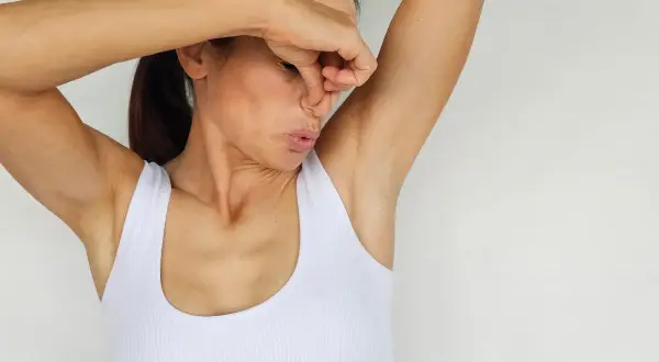 Donna che si tappa il naso, con espressione disgustata, per via dell'odore delle ascelle. Ecco perché si suda.