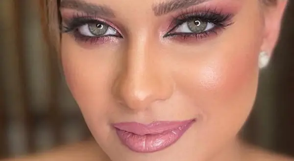 Occhi verdi con ombretto rosa e labbra lucide, un look perfetto per un trucco primaverile.
