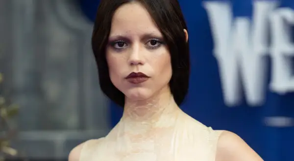 Donna con trucco Halloween semplice: occhi scuri, labbra bordeaux e pelle effetto squame.