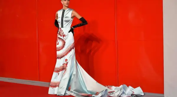 Modella con abito azzurro e draghi rossi, un look da tappeto rosso a look venezia.