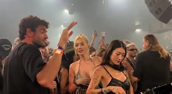 Matteo Berrettini con la sua fidanzata e amici in un locale notturno, tra DJ e folla festante.