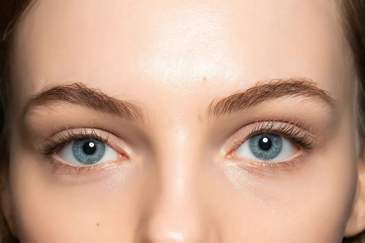 Occhi azzurri luminosi, evidenziati da un trucco leggero e naturale che ne esalta la profondità. Ciglia lunghe e definite completano il look.
