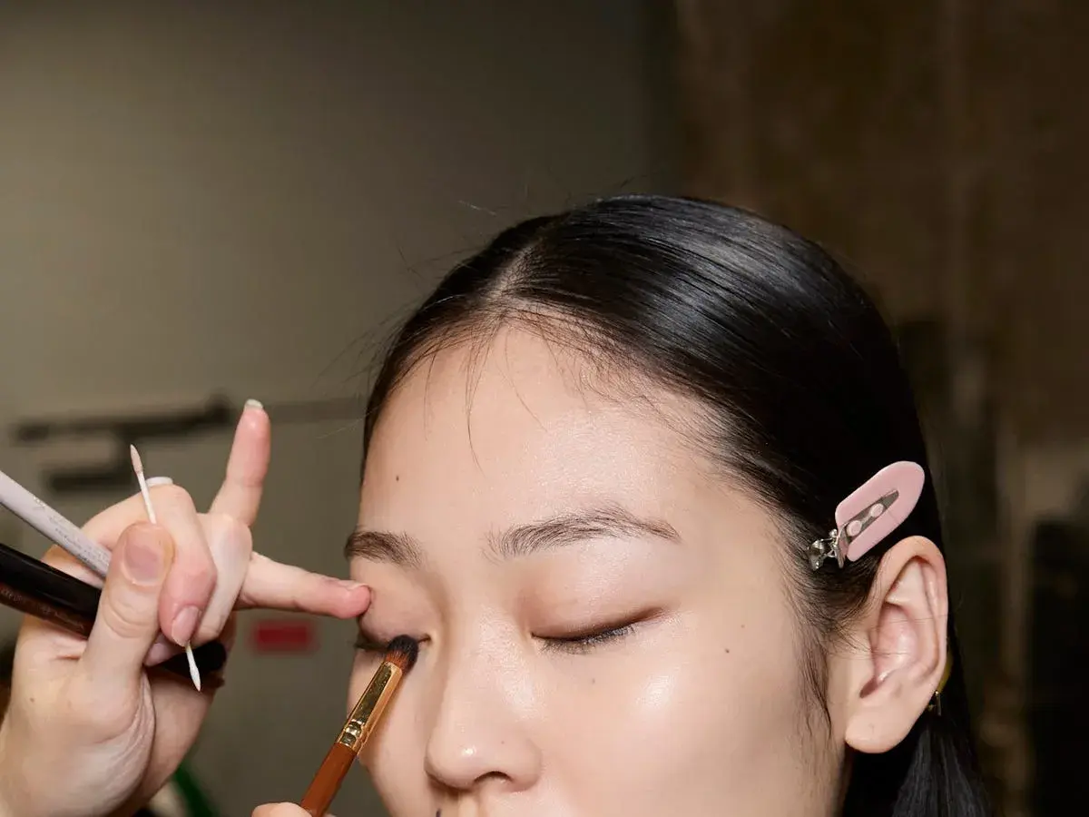 Applicazione ombretto con pennelli trucco come usarli. Dettaglio di un occhio mentre viene truccato.
