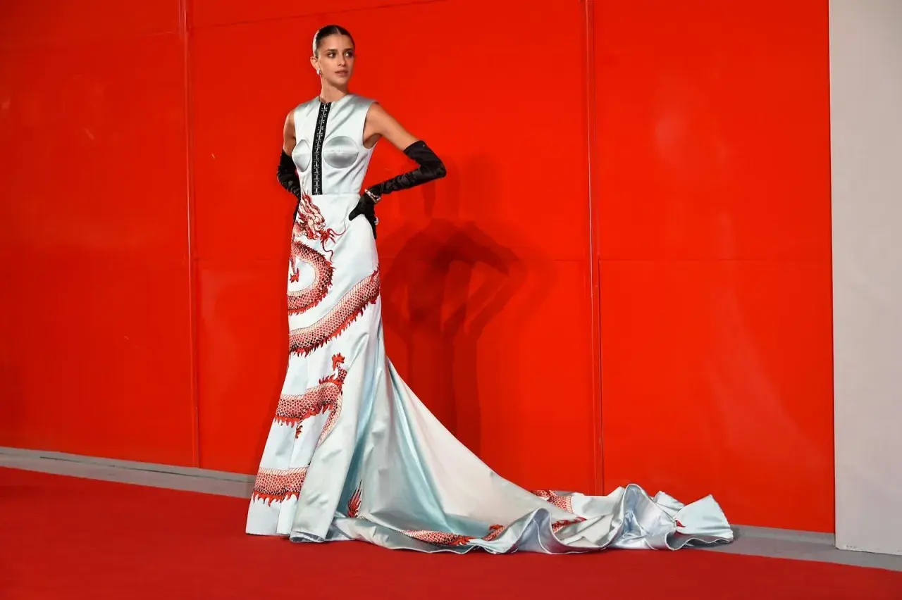 Modella con abito azzurro e draghi rossi, un look da tappeto rosso a look venezia.