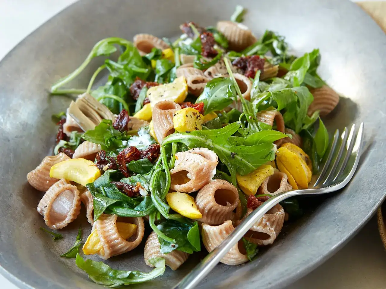Pasta integrale con rucola, zucchine e pomodori secchi. Un piatto gustoso, ma attenzione a cosa non mangiare per dimagrire: troppi carboidrati raffinati e condimenti grassi.