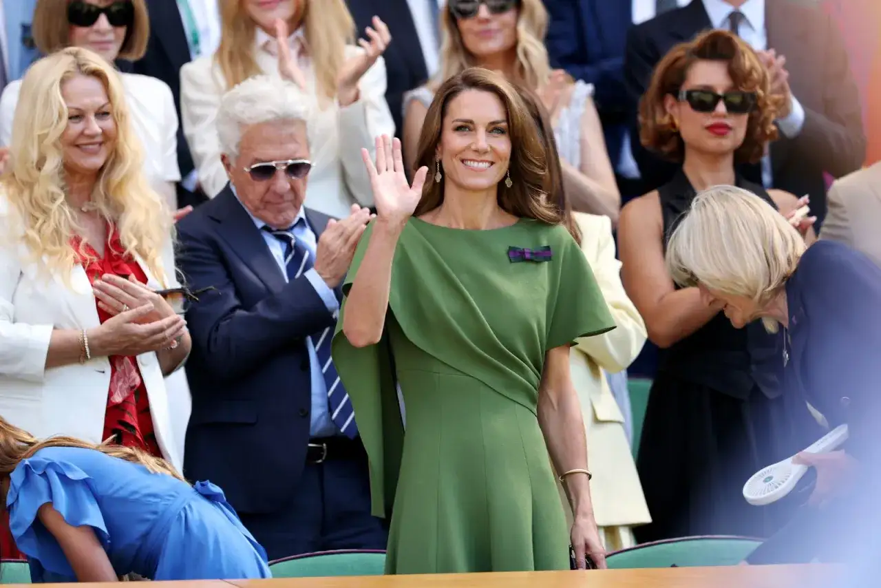 Kate Middleton a Wimbledon saluta il pubblico con un sorriso, vestita di verde.