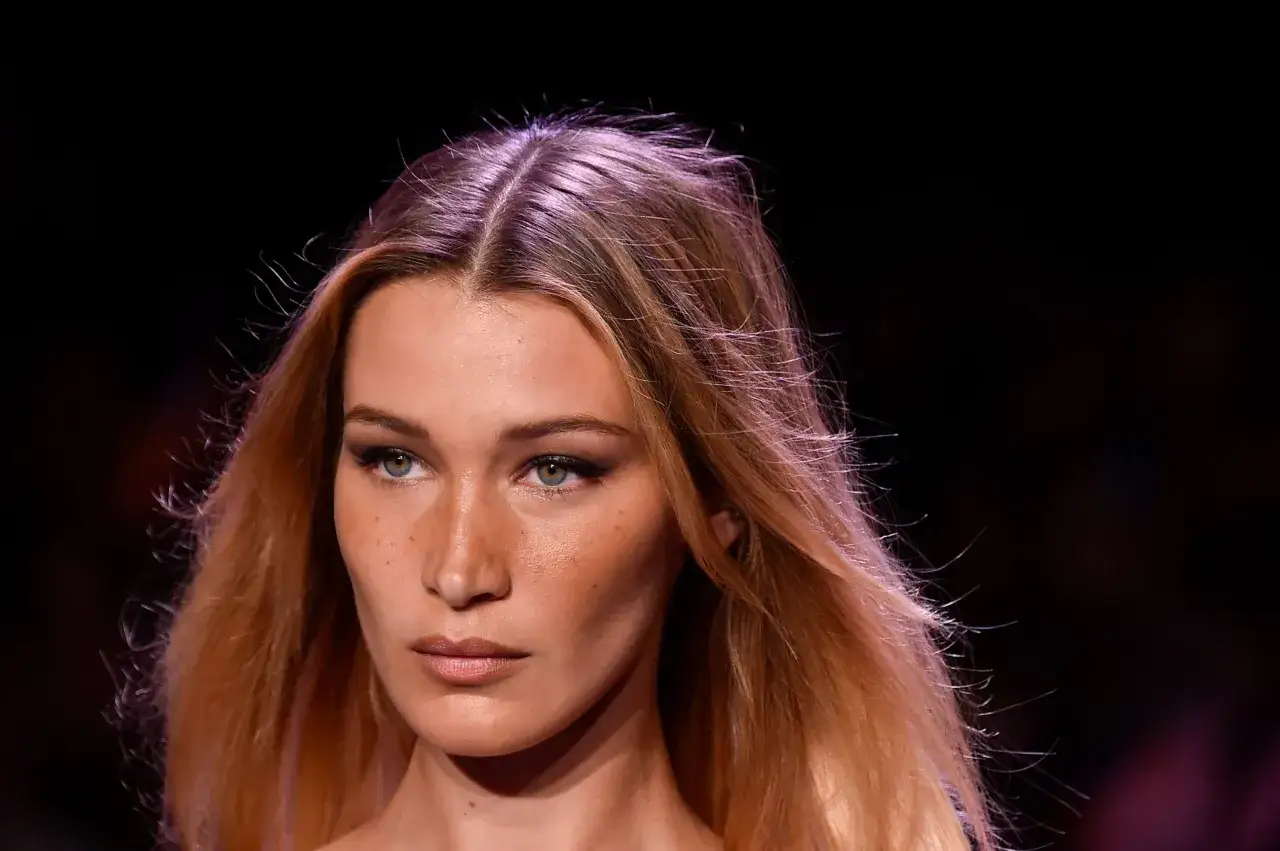 Primo piano di una donna con capelli biondi mossi e occhi verdi penetranti. Sembra la donna pi&ugrave; bella del mondo, con un trucco leggero che esalta la sua bellezza naturale.