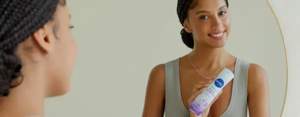 Donna sorridente con spray Nivea Fresh Sensation, un modo per non sudare e sentirsi freschi tutto il giorno.