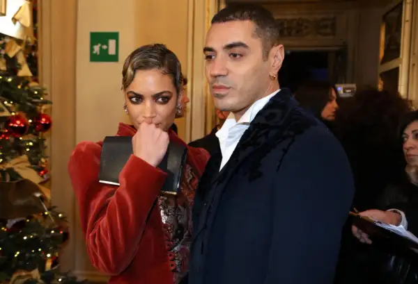 Elodie e Marracash, una coppia elegante, posano vicino a un albero di Natale addobbato.