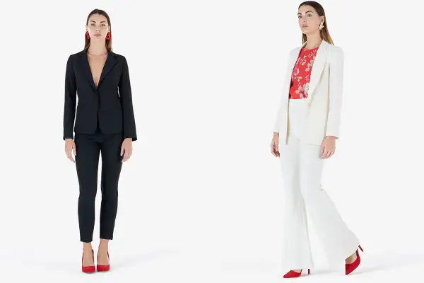 Modelli con giacca e pantaloni eleganti. Una con giacca nera e pantaloni slim, l'altra con giacca bianca e pantaloni a zampa.