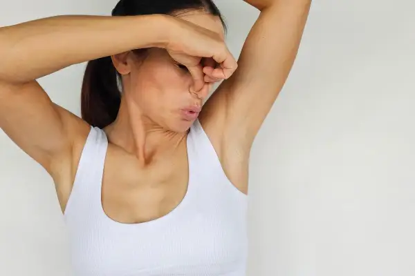 Donna che si tappa il naso, con espressione disgustata, per via dell'odore delle ascelle. Ecco perché si suda.