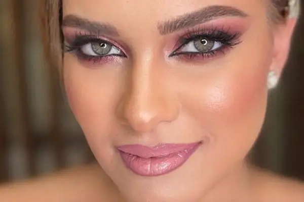 Occhi verdi con ombretto rosa e labbra lucide, un look perfetto per un trucco primaverile.