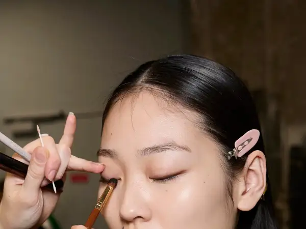 Applicazione ombretto con pennelli trucco come usarli. Dettaglio di un occhio mentre viene truccato.